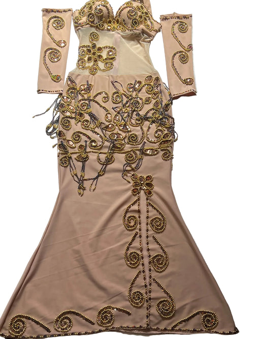 Beige evening gown with gold embroidery on a patterned surface