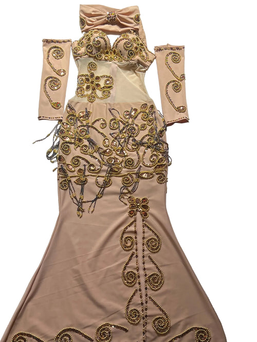Beige evening gown with gold embroidery on a patterned surface