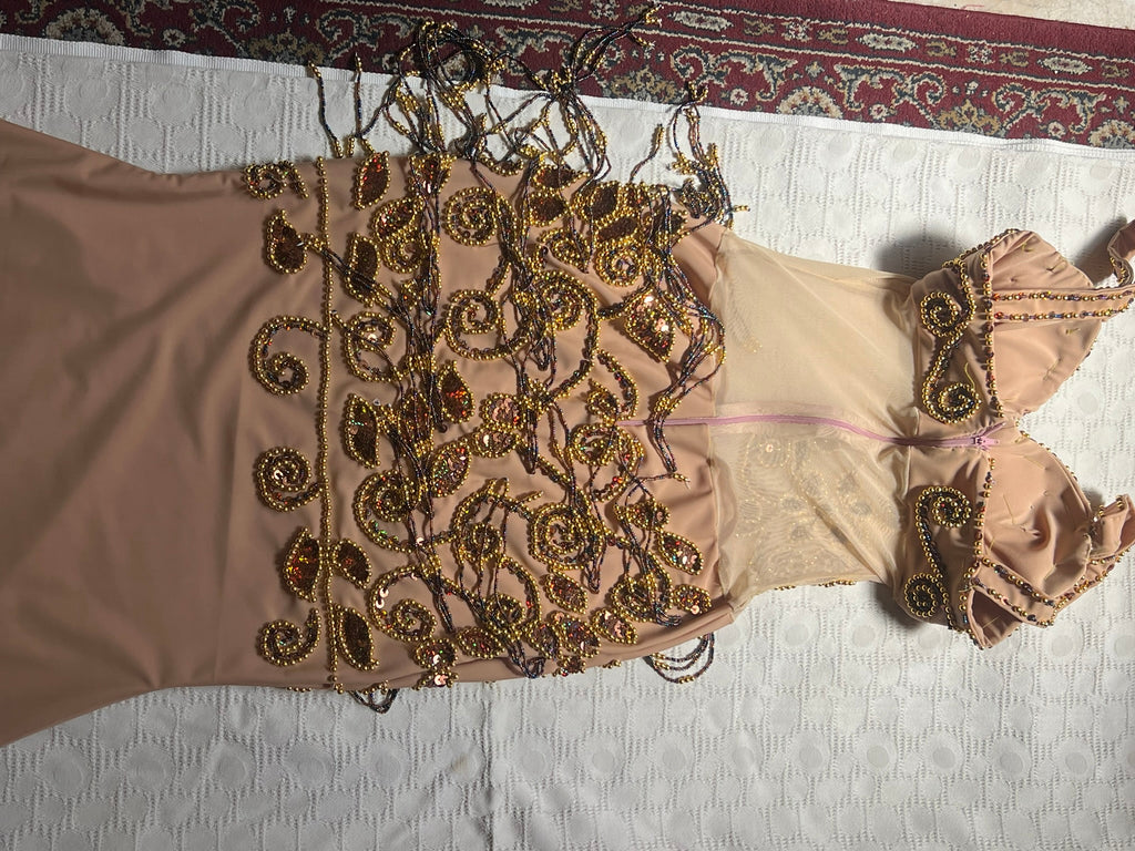 Backside view of Beaded dress on a white surface with a patterned rug in the background