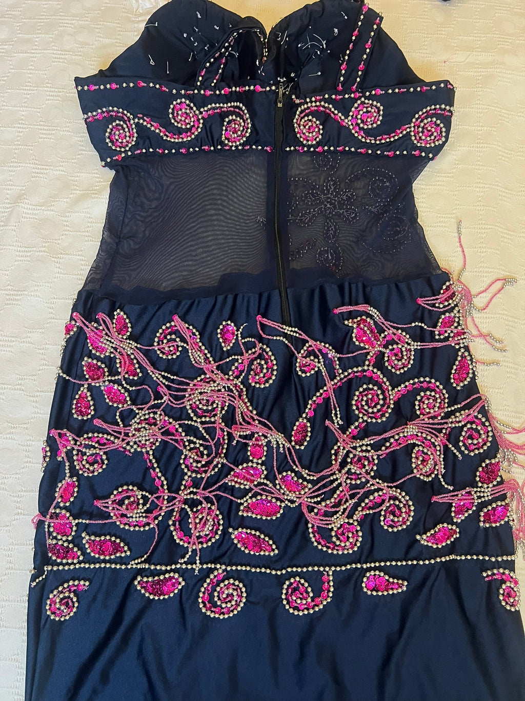 Back view of Navy Blue belly dance dress with pink embroidery on a light White surface