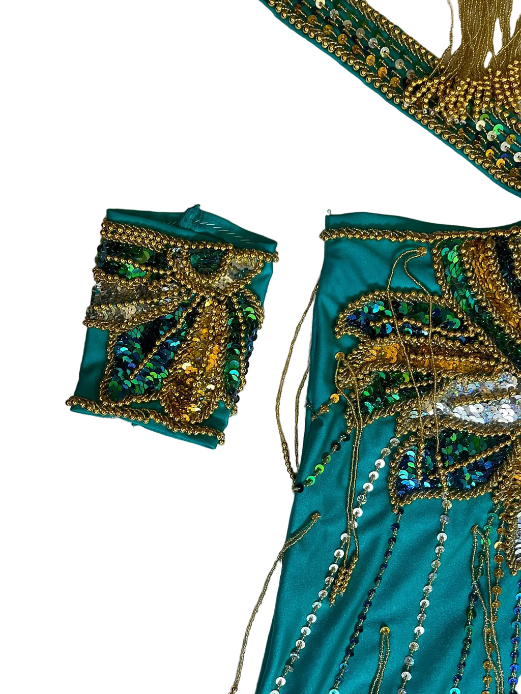 Teal fabric with gold and green embroidery on a textured white background