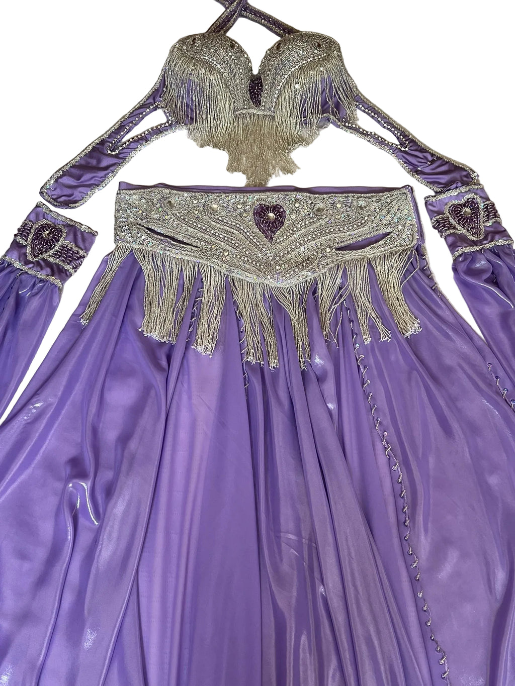 Purple costume with intricate beading and fringes on a textured surface
