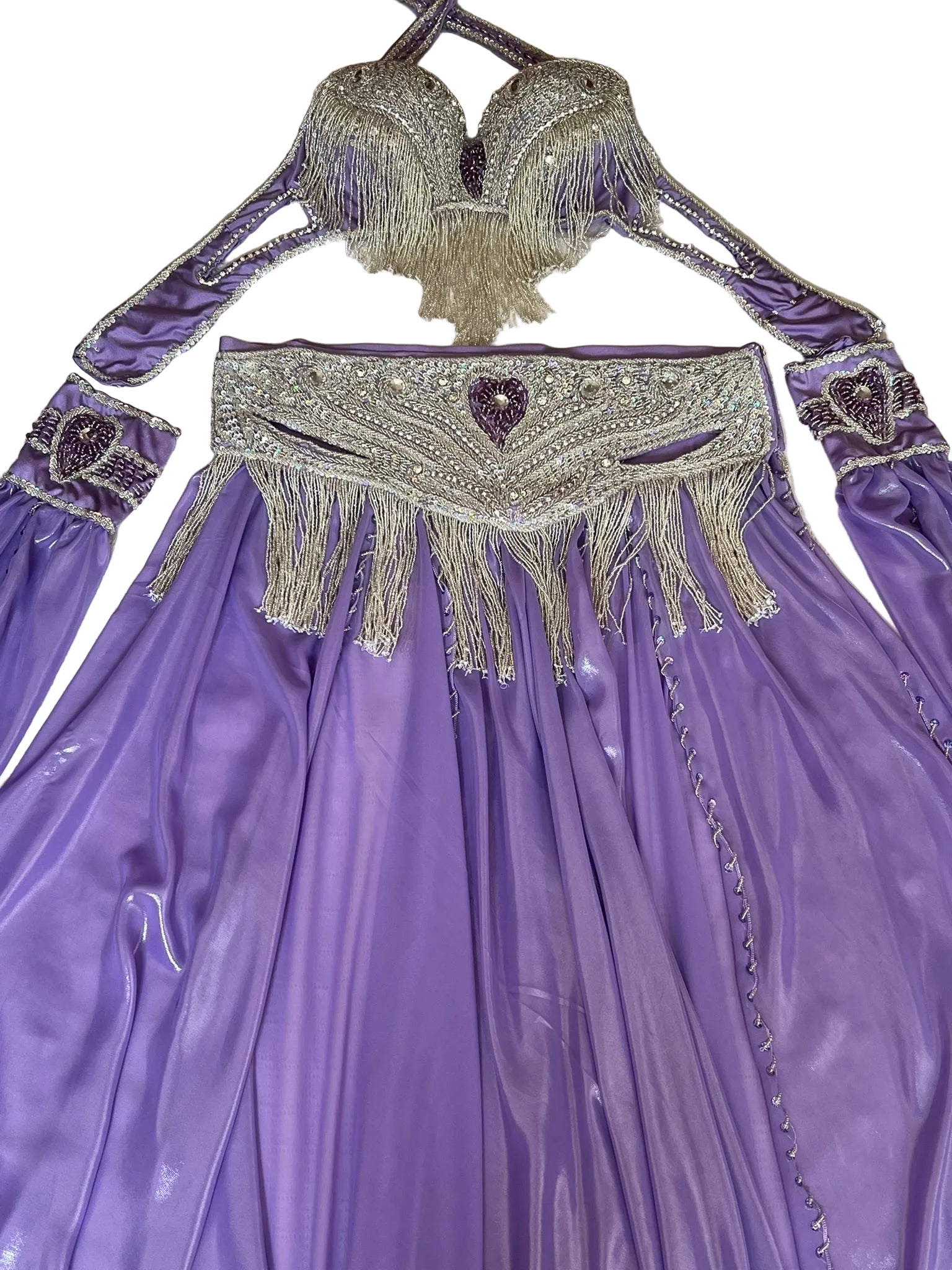Purple costume with intricate beading and fringes on a textured surface