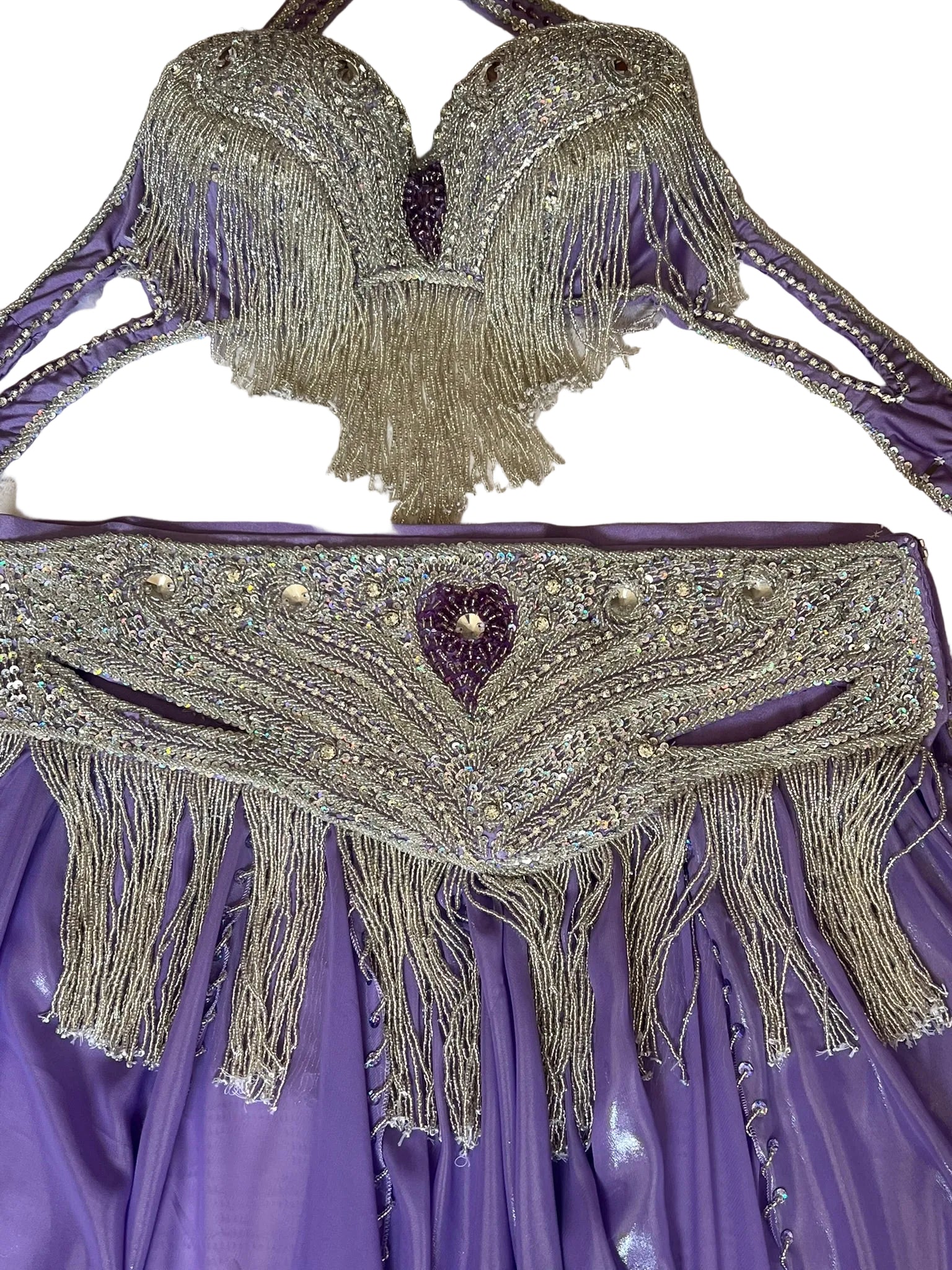 Decorative purple garment with beaded fringe and heart detail on a white background