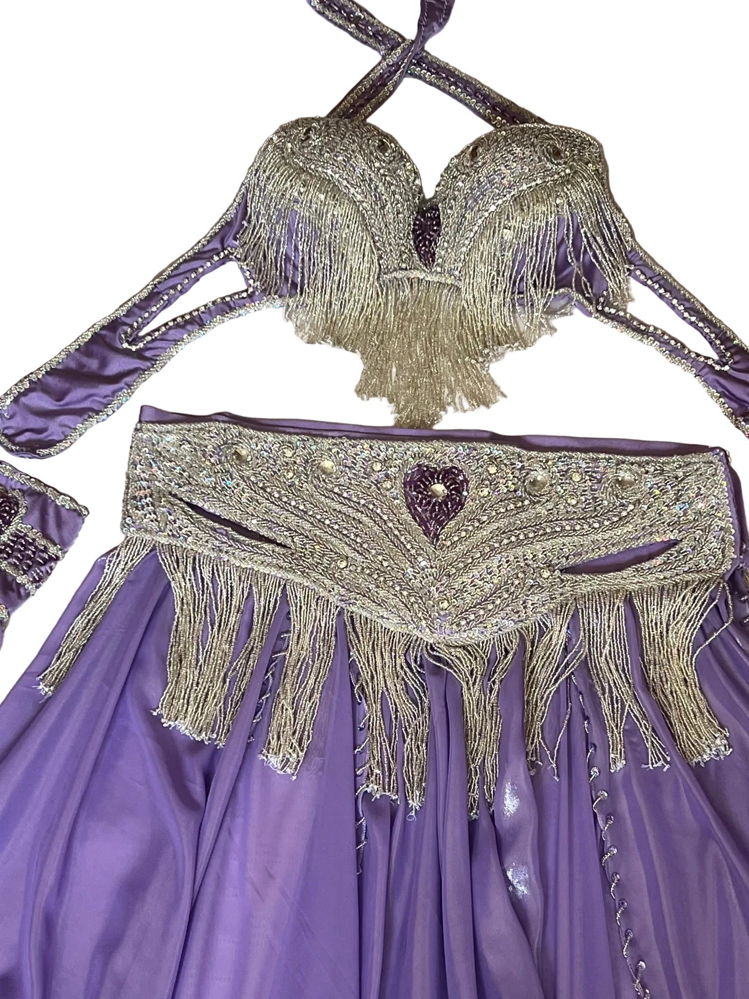 Purple outfit with silver fringe and heart detail on a textured surface