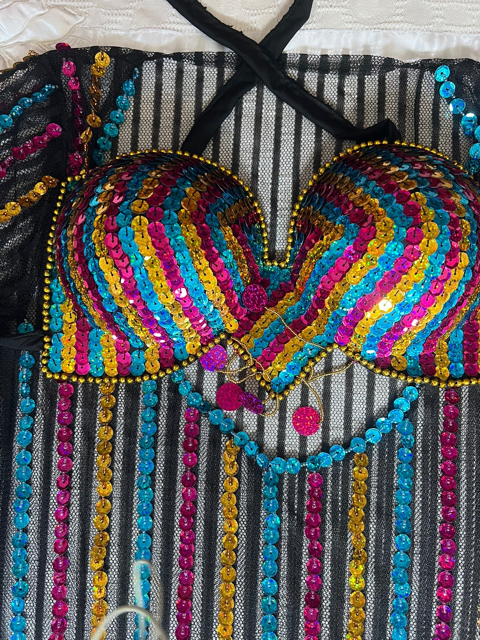 Colorful beaded top with intricate patterns on a textured background