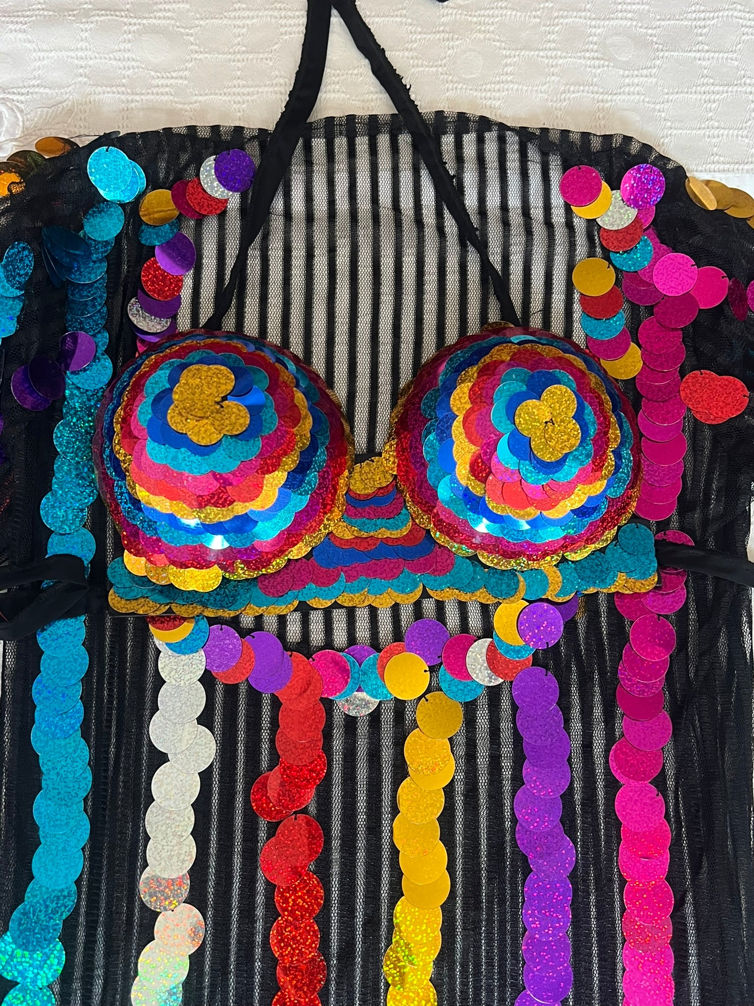 Colorful bra with sequins on a black and white striped background