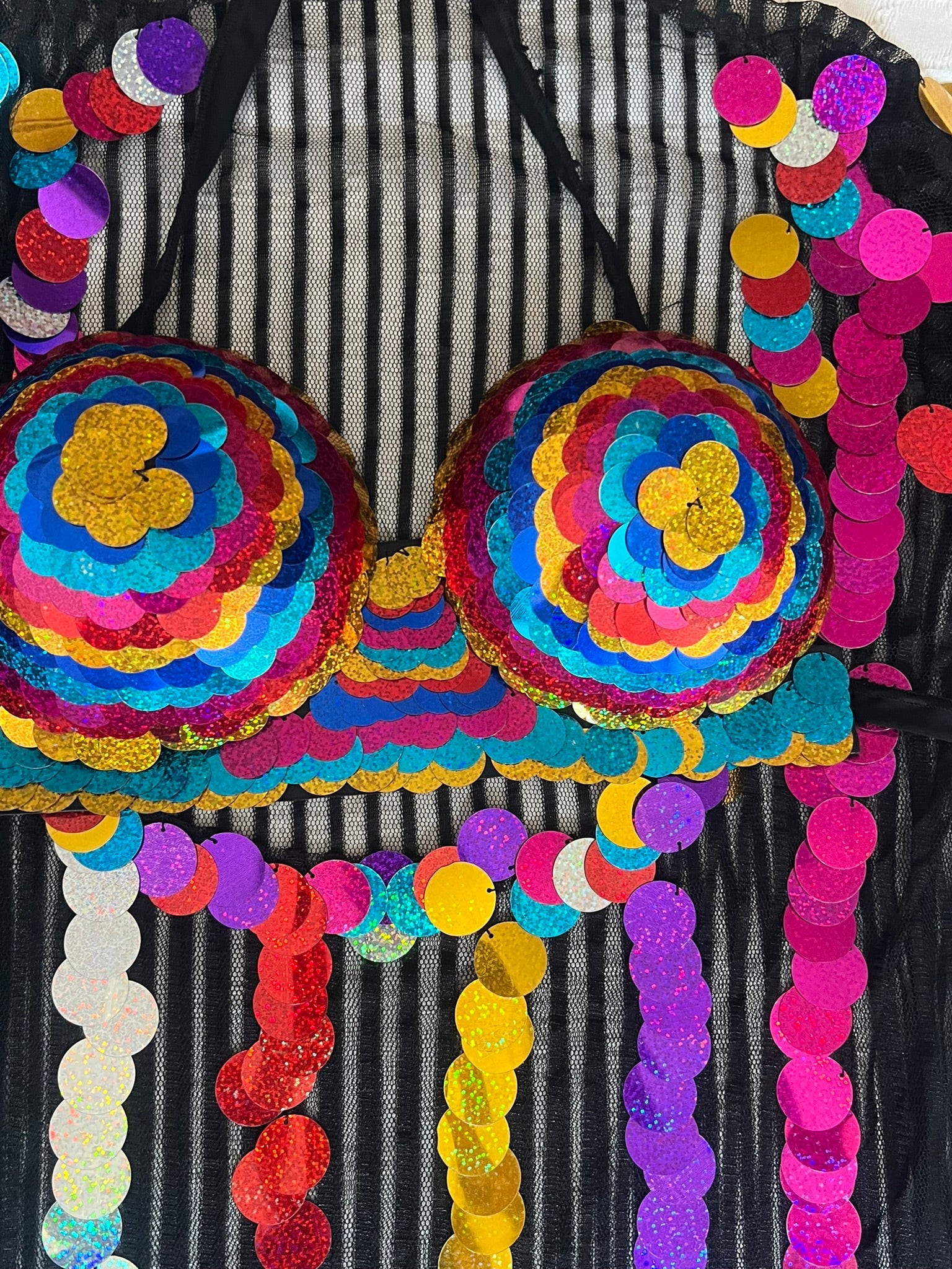 Colorful bra with sequin details on a black and white striped background