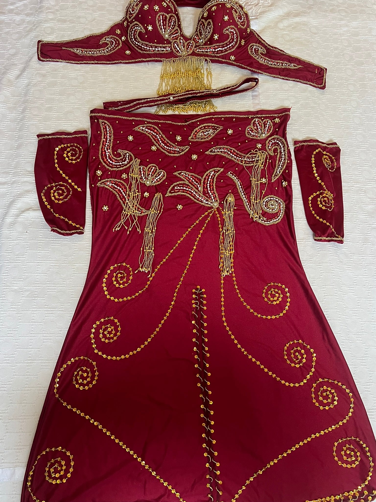 Maroon traditional Dancing outfit with gold embroidery on a white background 