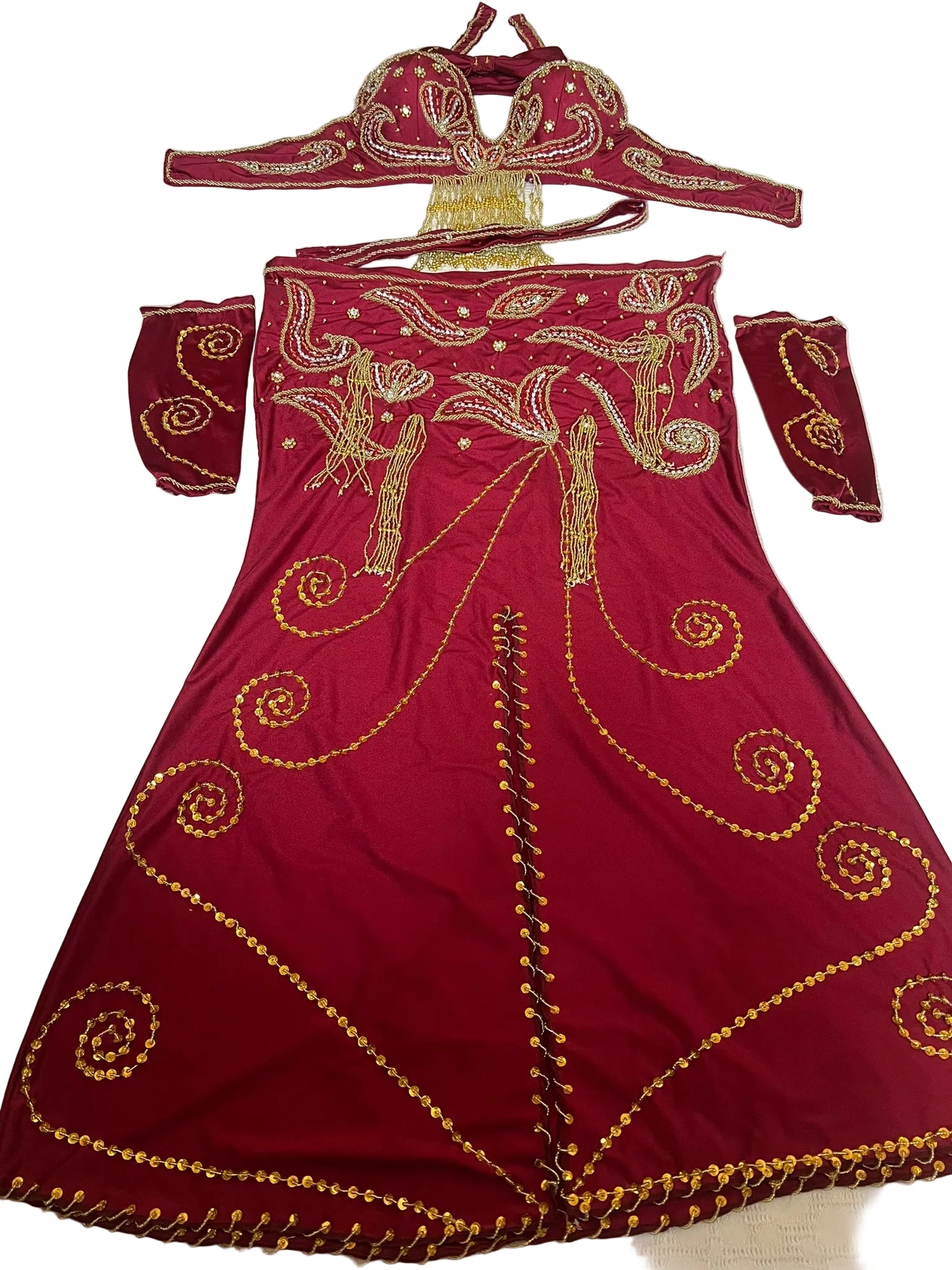 Red embroidered Belly dance outfit with gold details on a white surface