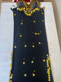 A black belly dance costume with handmade embroidered details and large sequins, displayed on a flat surface.
