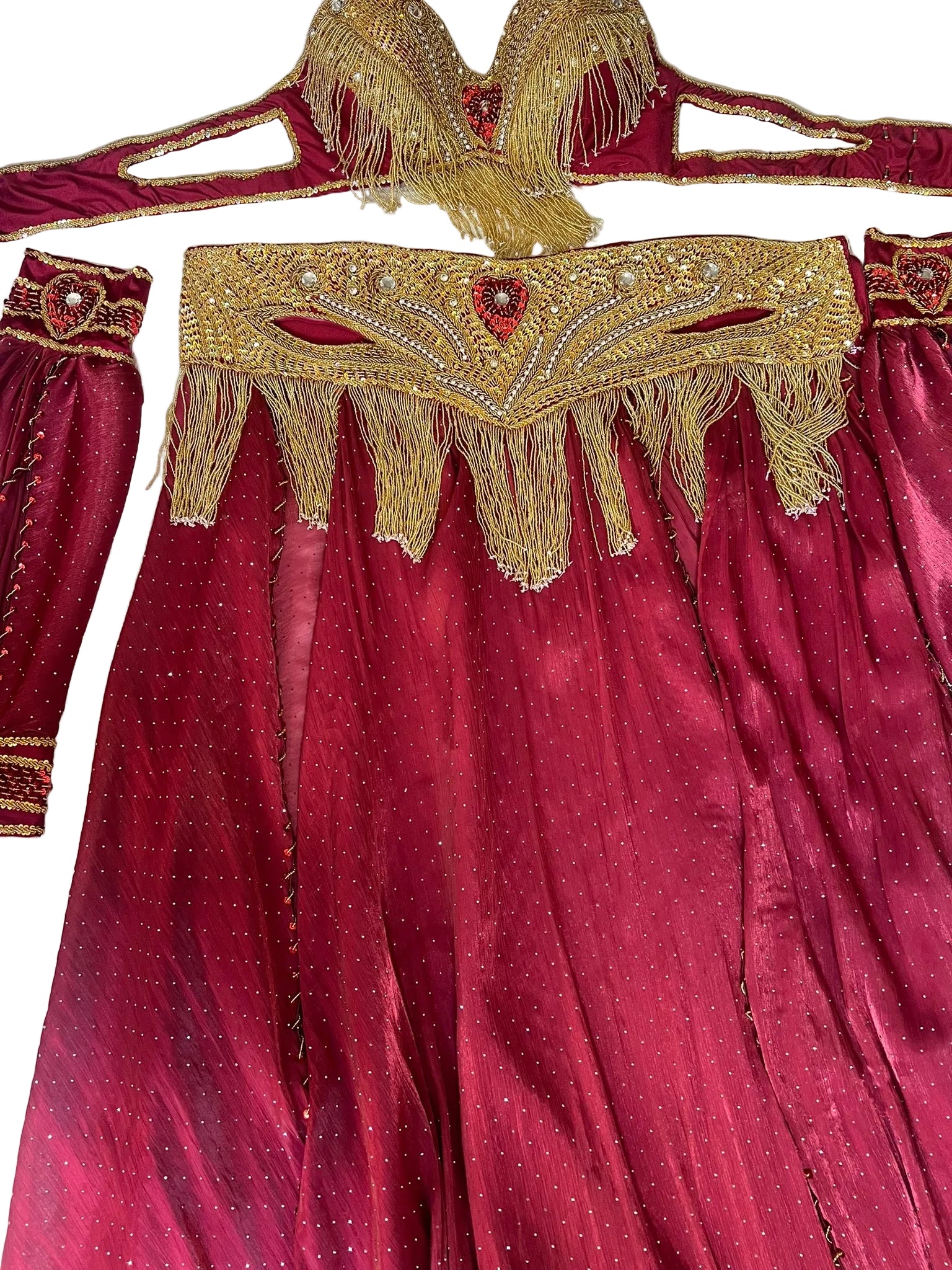 Maroon outfit with gold embroidery and fringes on a white background