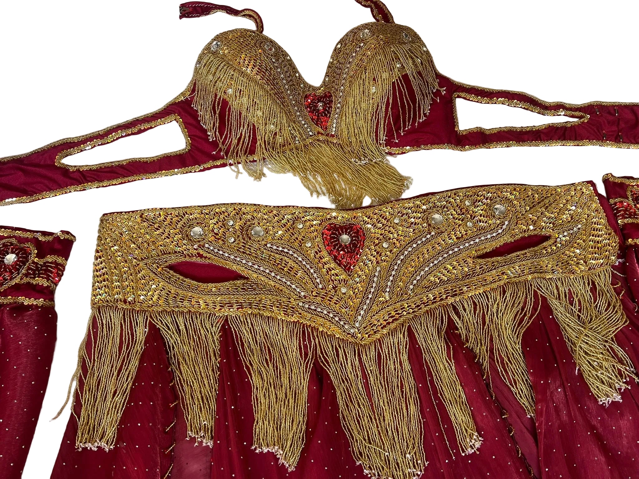 Decorative gold belly dance belt with fringes and red fabric background