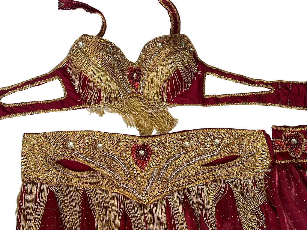 Decorative gold and red dance garment with intricate patterns on a white background