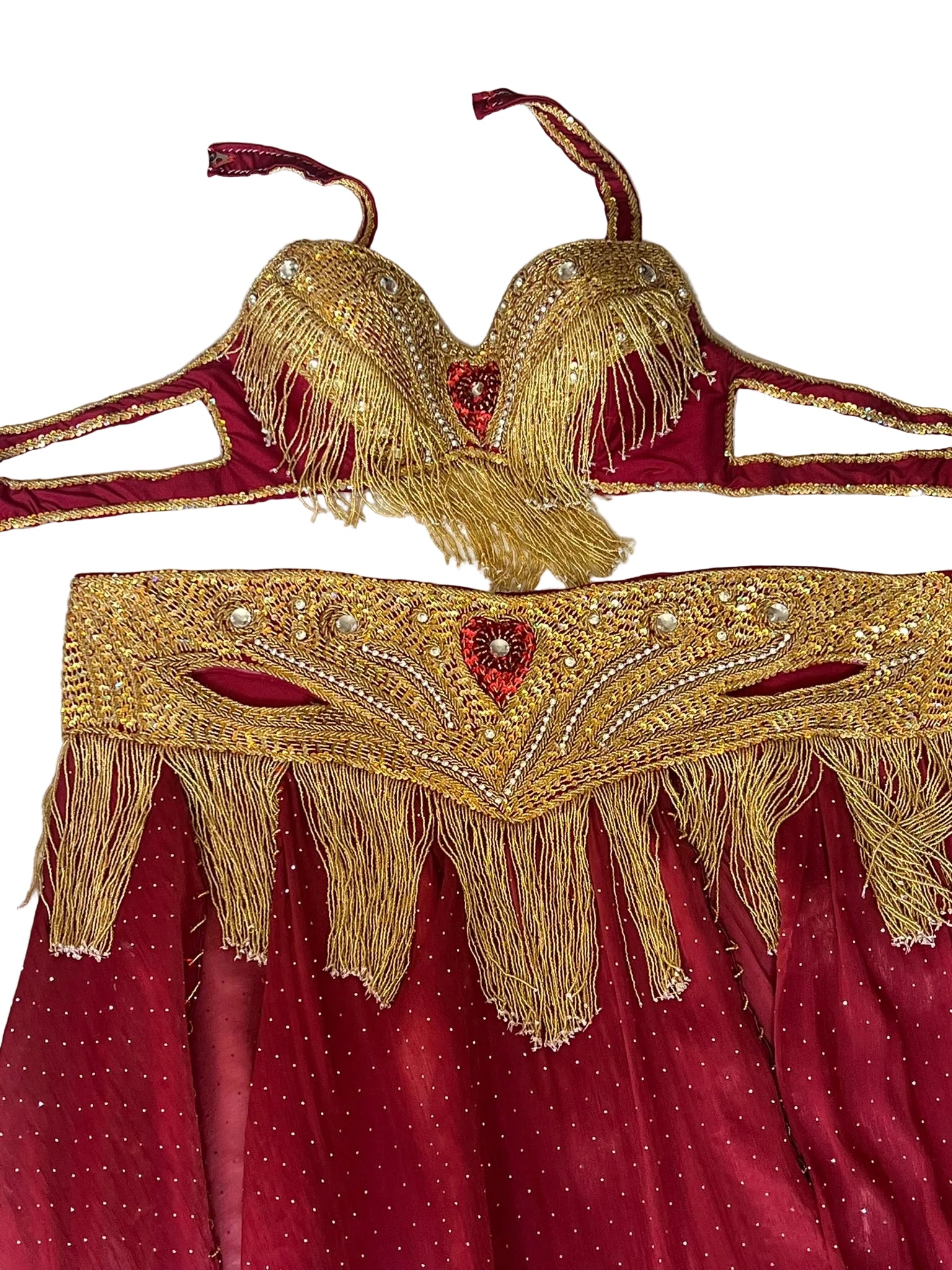 Red and gold costume with intricate designs on a textured white background