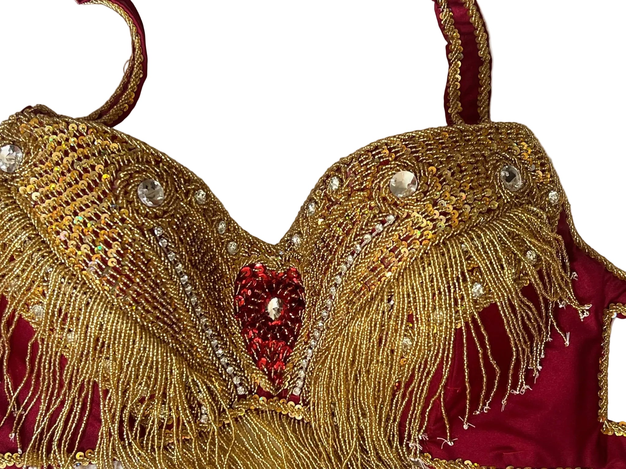 Decorative belly dance bra with gold embroidery and red accents on a white background