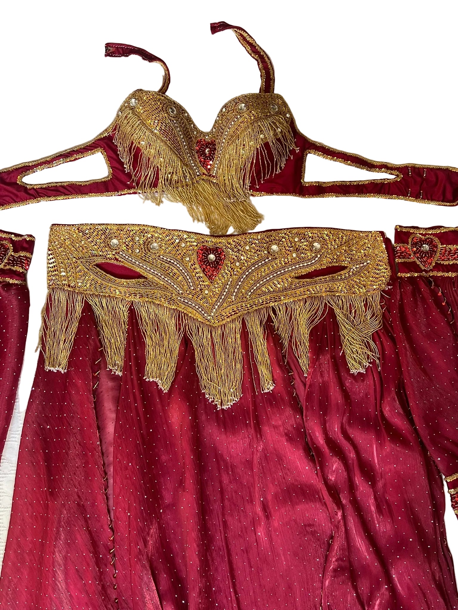 Maroon belly dance outfit with gold embroidery and fringe on a white background
