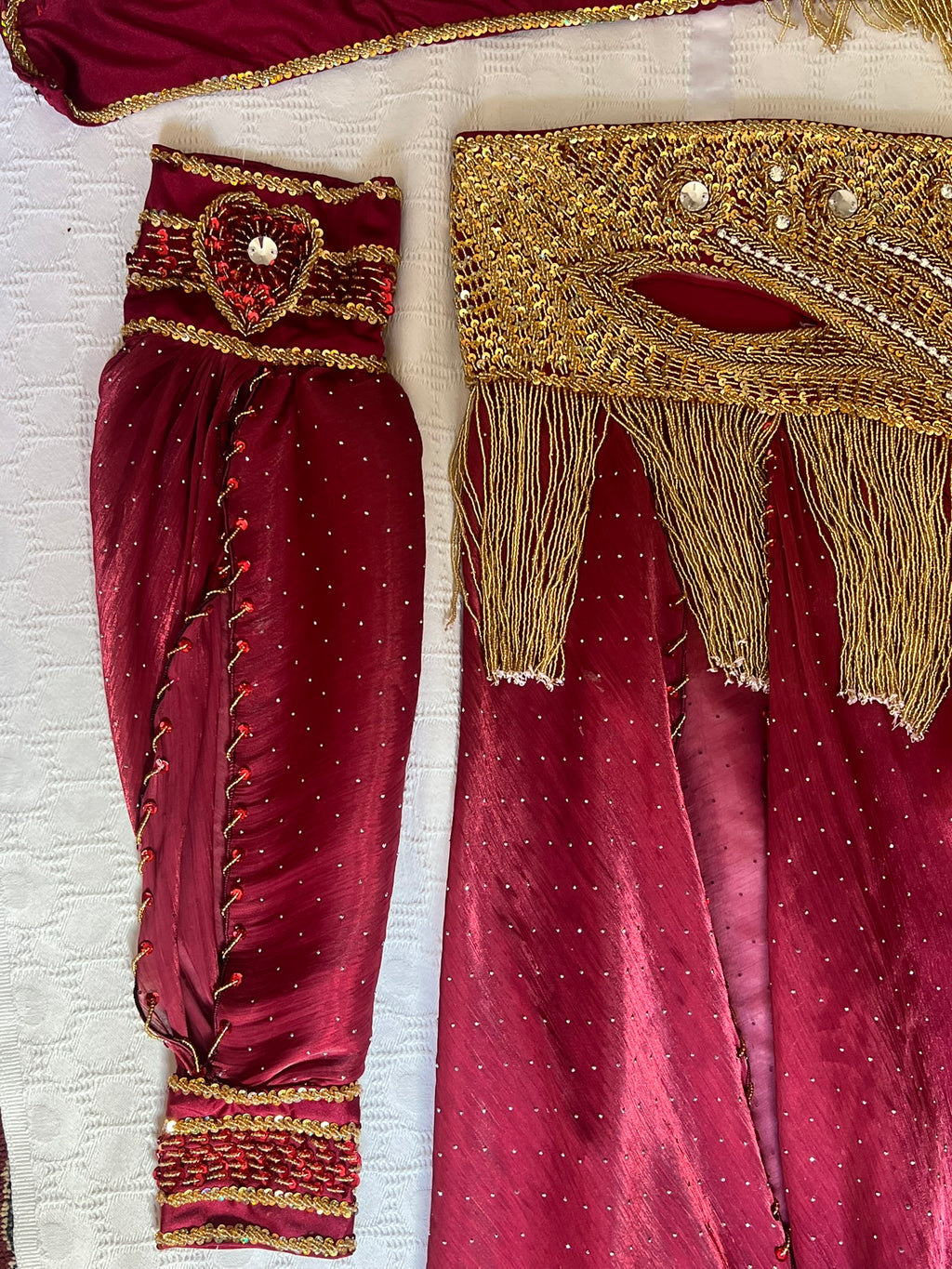 Maroon traditional outfit with gold embroidery on a white background