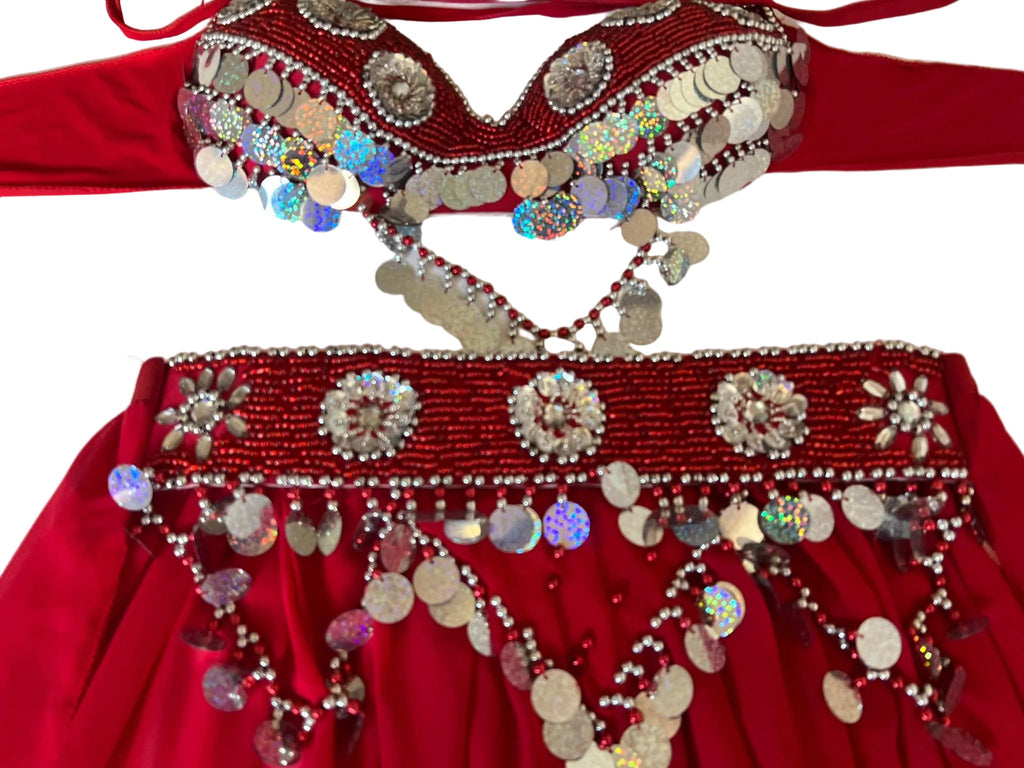 Red outfit with intricate beading and coin embellishments on a white background