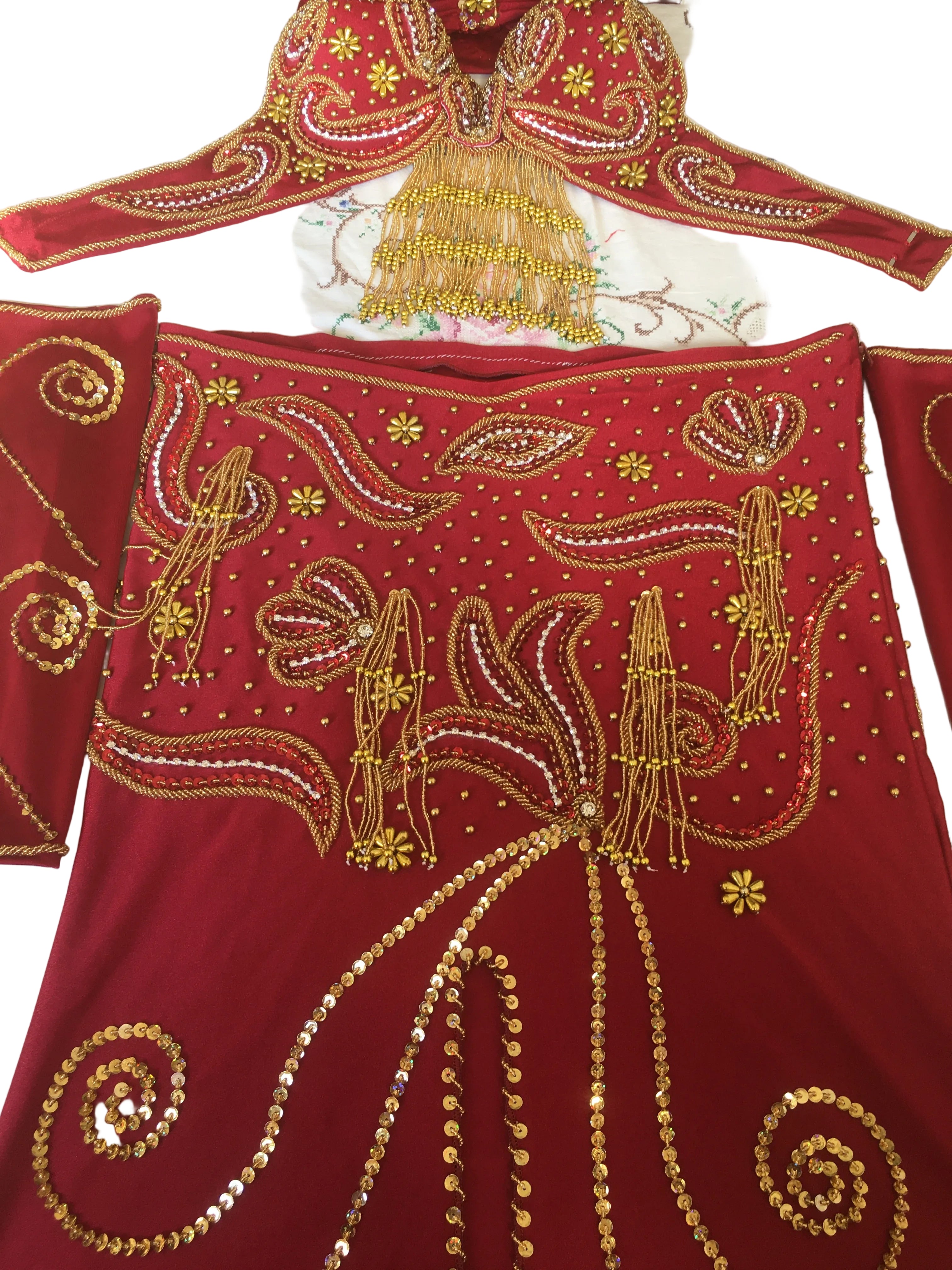 Red fabric with gold embroidery on a white background