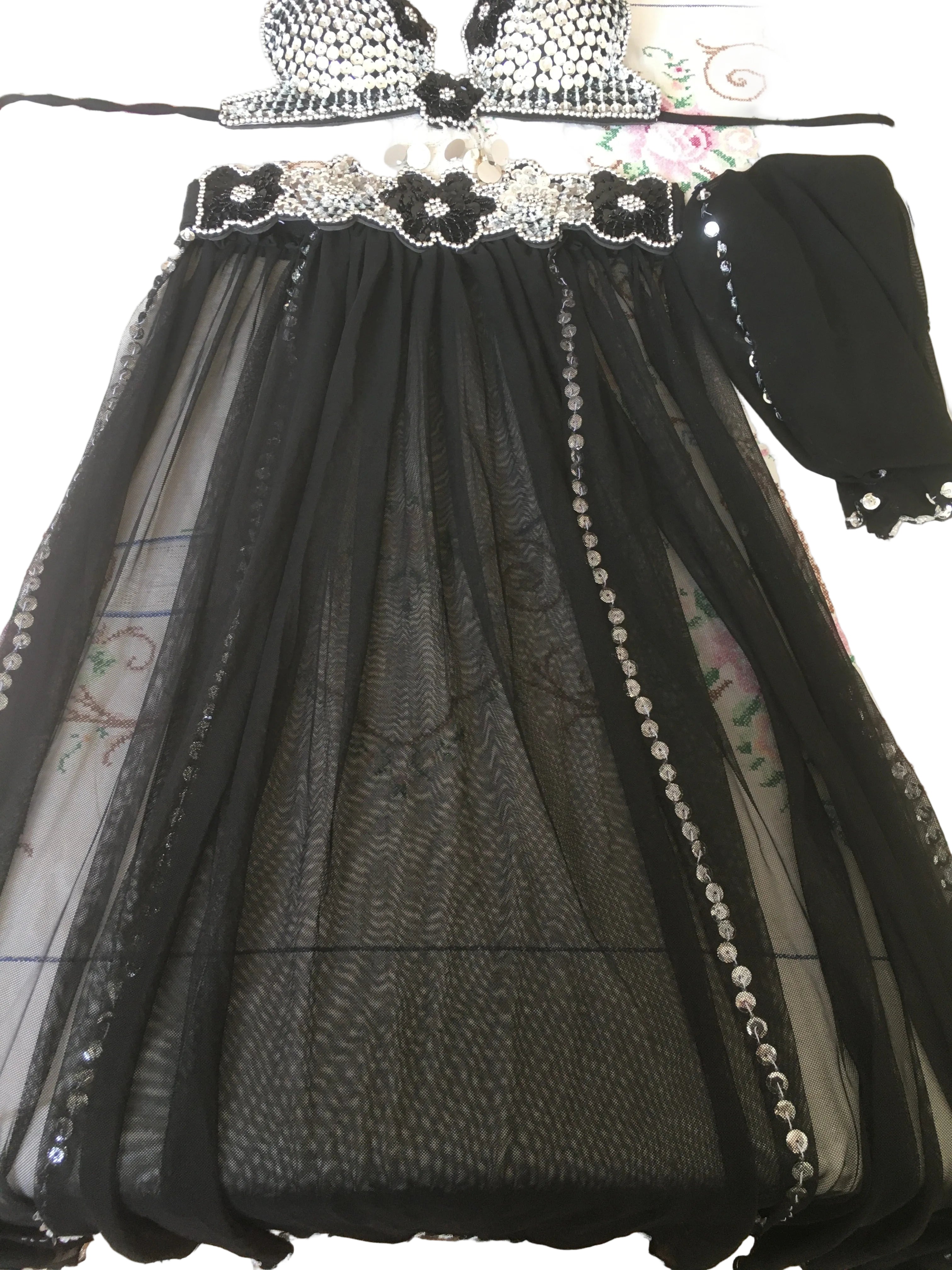Black embroidered dress with sheer overlay on a white background