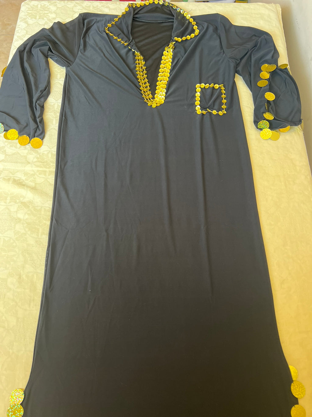 Gray dress with yellow embellishments on a beige surface