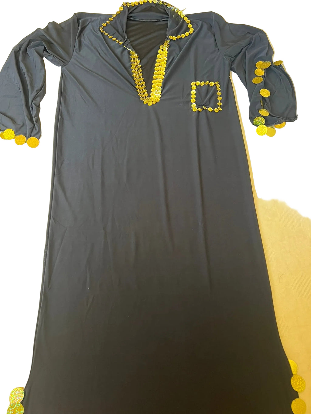 Gray dress with yellow embellishments on a beige surface