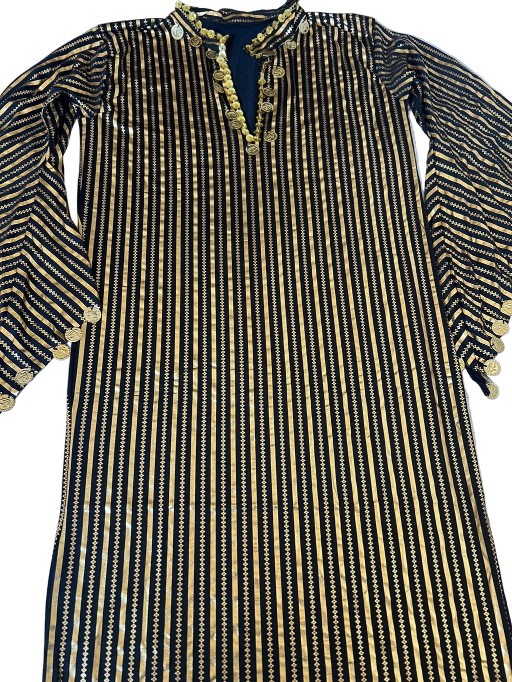 Black and gold striped dress with intricate detailing on a light blue surface