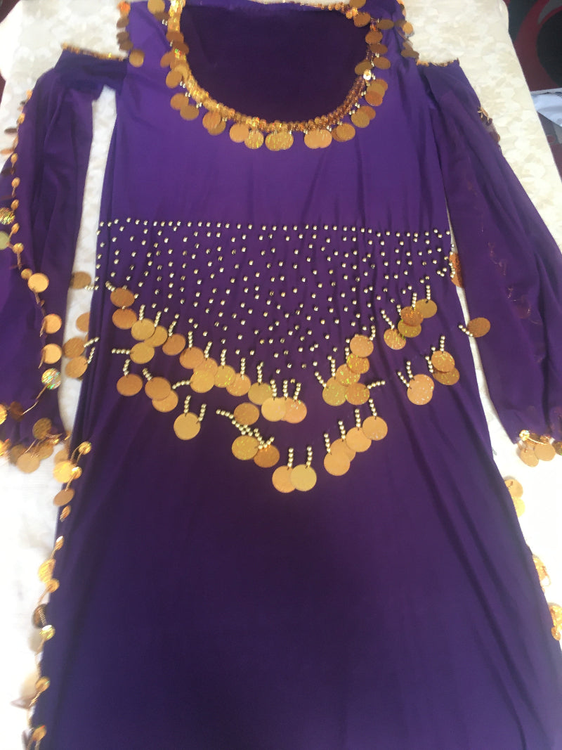 A purple belly dance dress with gold embroidery and a flowing abaya.
