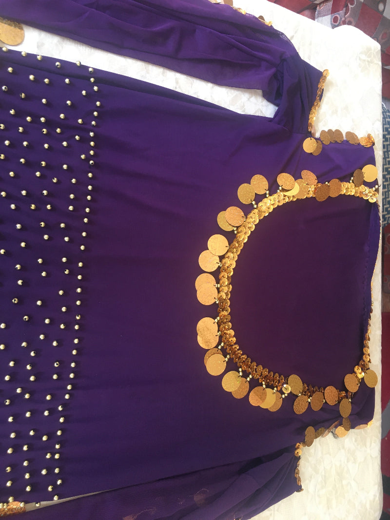A purple belly dance dress with gold embroidery and a flowing abaya.
