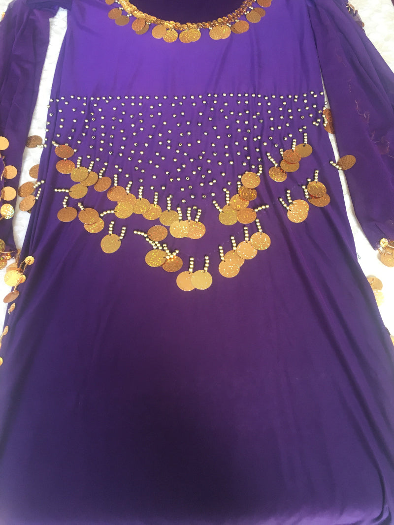 A purple belly dance dress with gold embroidery and a flowing abaya.