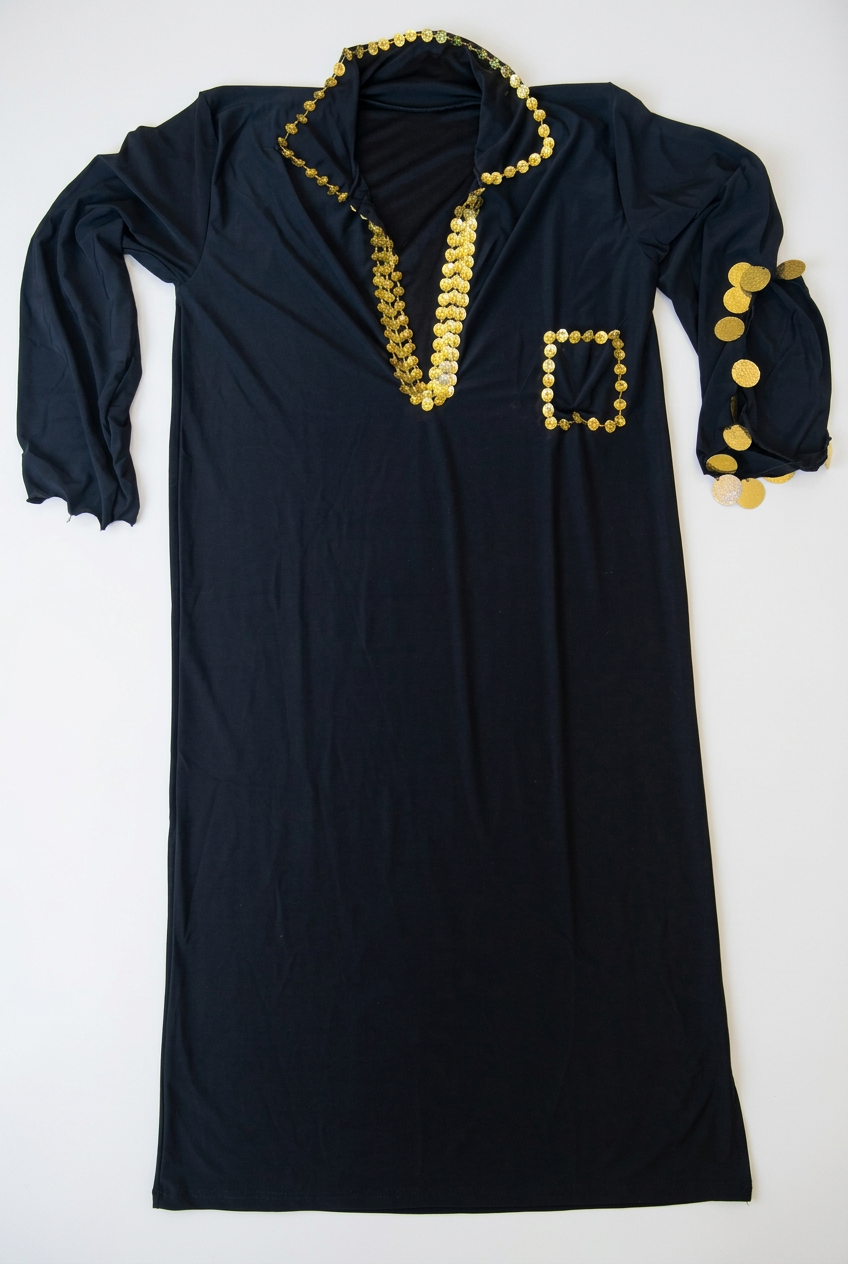 Black Egyptian Saidi galabia laid flat on a beige surface, showing gold-tone sequin edging and split sleeves.
