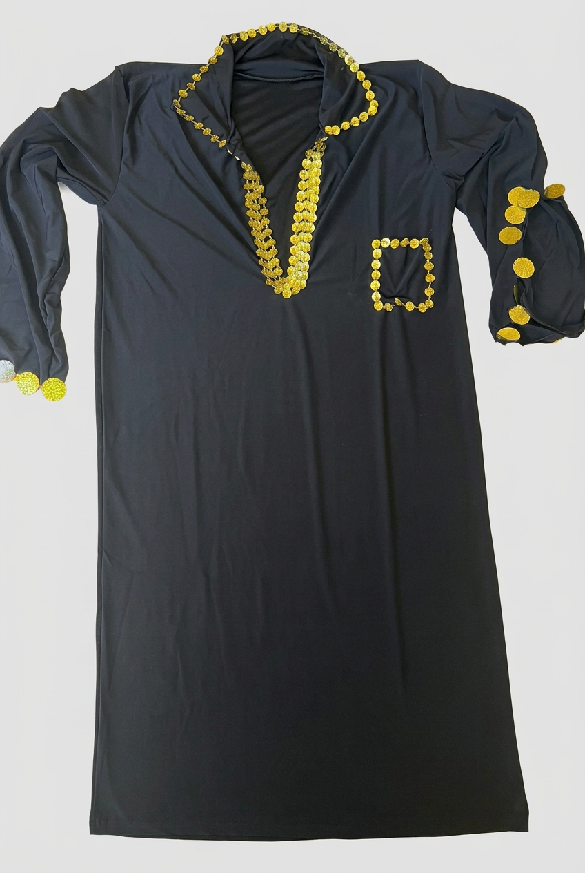 Black Saidi belly dance dress laid flat on a beige surface, with gold-tone sequin trim around the neckline, pocket, sleeves and side slits.
