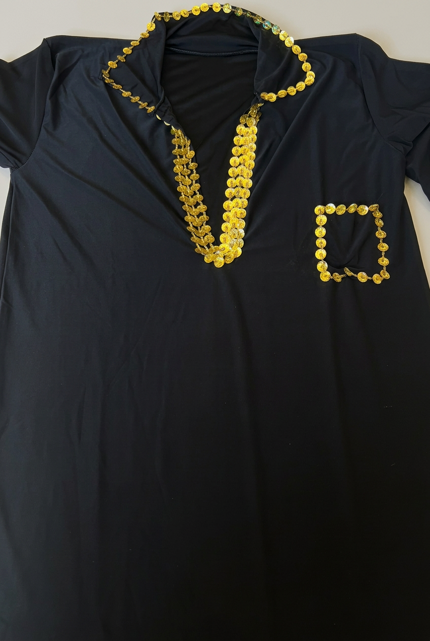 Close-up of a black Saidi belly dance galabia showing gold-tone sequin trim around the collar, deep neckline and chest pocket.
