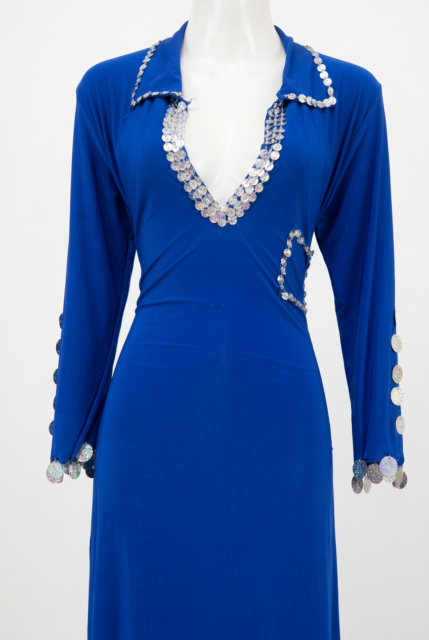 Close-up of a royal blue belly dance galabia on a mannequin, showing silver-tone sequin trim around the collar, neckline and chest pocket.

