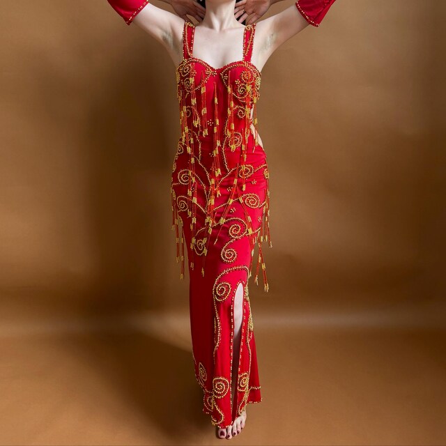 Red embroidered Belly dance dress with gold details on a brown background