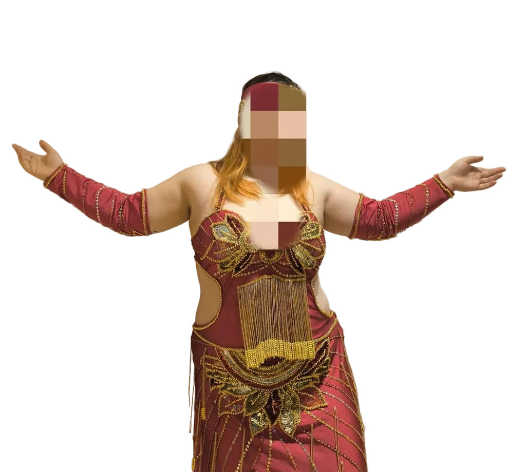 Person wearing a red and gold traditional outfit with arms outstretched on a white background