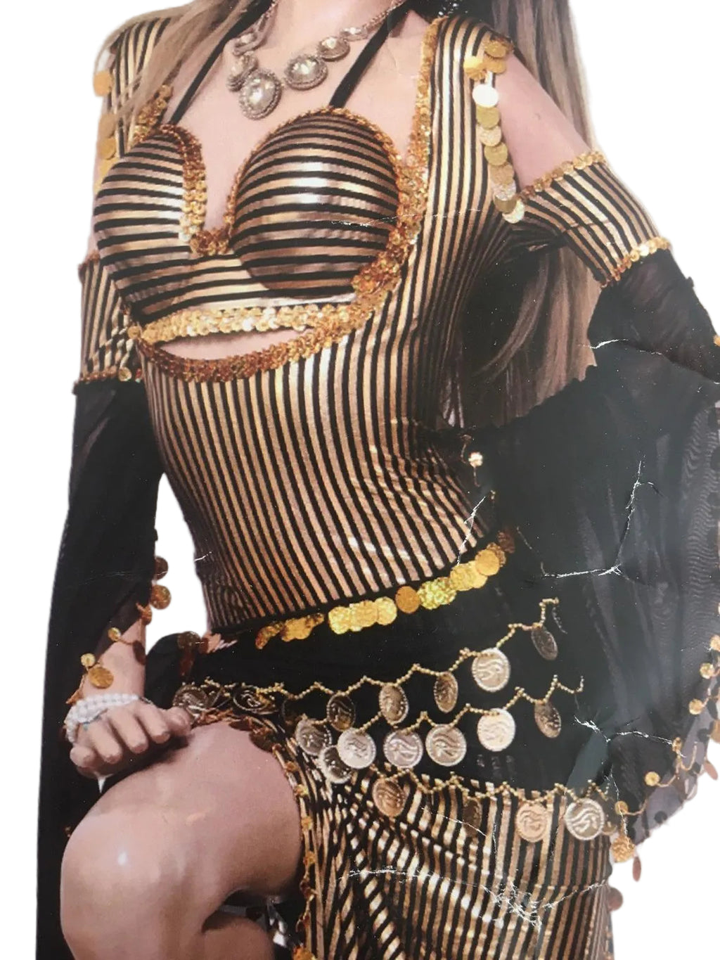 Person wearing a black and gold outfit with intricate designs and patterns.