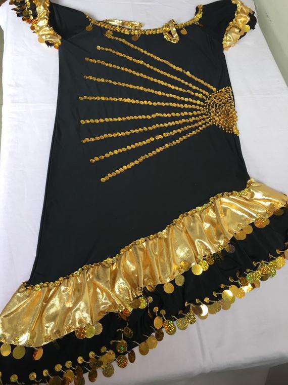 A black and gold belly dance dress with embroidered sequins and glass beads, displayed on a white surface.