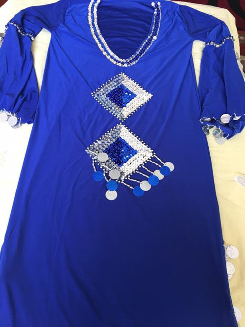 A blue belly dance dress with handmade embroidery and silver accents on a white surface.