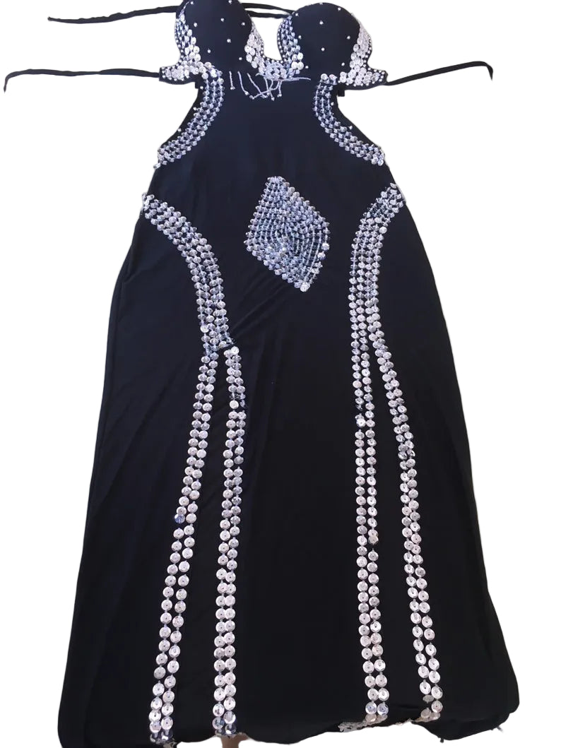 Black evening gown with white embellishments on a hanger against a white background