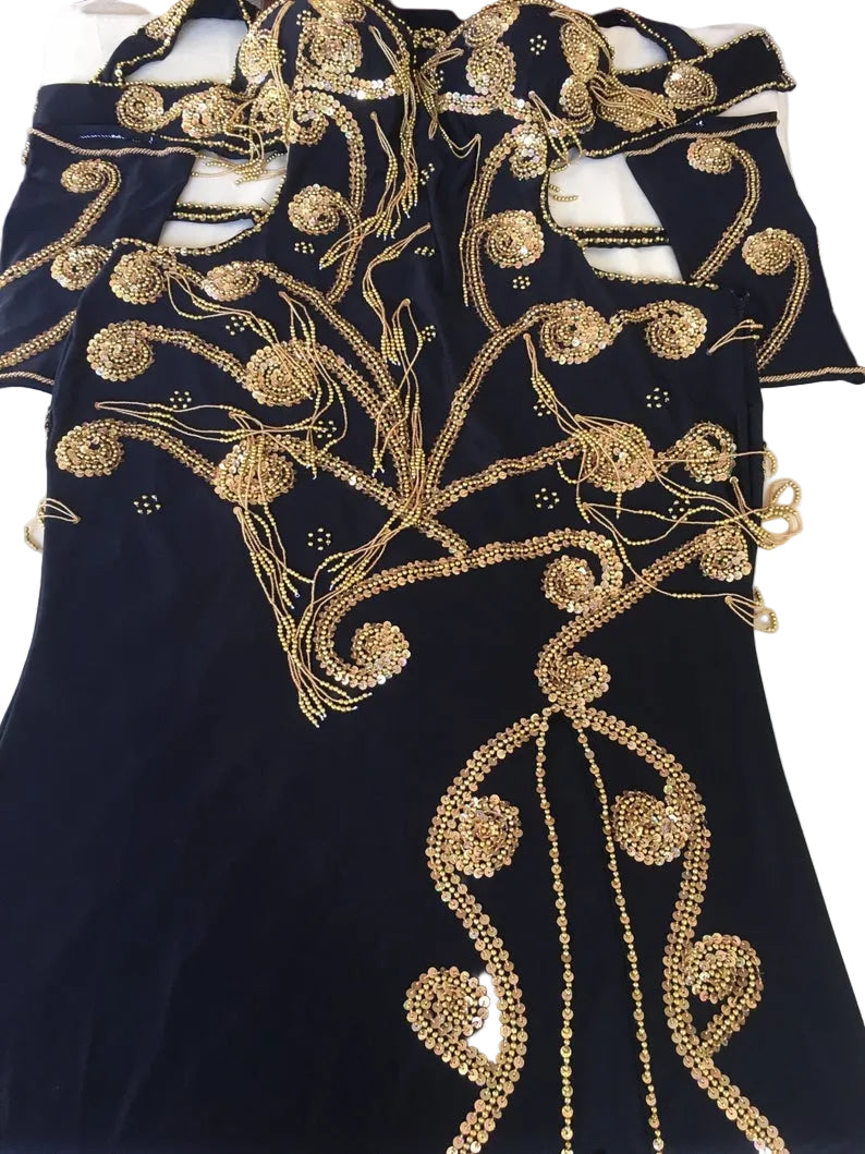 A professional custom-made belly dance costume featuring a black dress with gold embroidered patterns, along with two sleeves and a headband.
