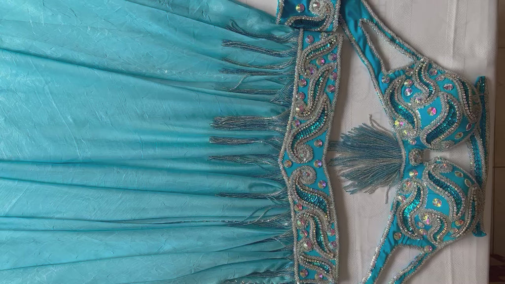 Video showcasing a premium handmade belly dance costume in turquoise fabric, beautifully adorned with silver beads, glass stones, and rhinestones.