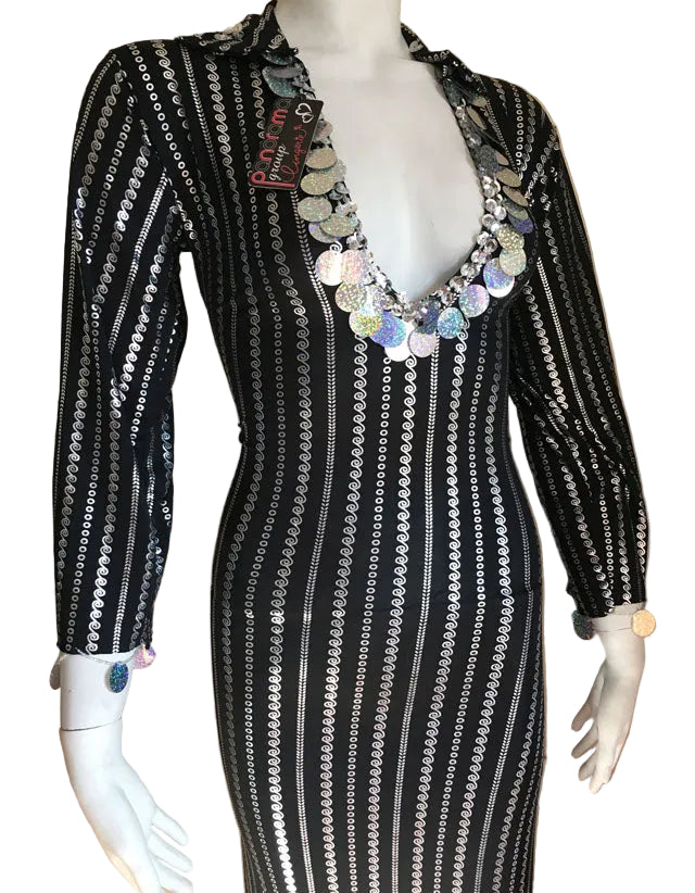 Mannequin wearing a black and white patterned dress with a colorful necklace against a beige background